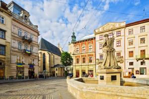 a statue in the middle of a street with buildings at Апартаменти з сауною на Площі Ринок для 4 -х гостей - в еко стилі in Lviv