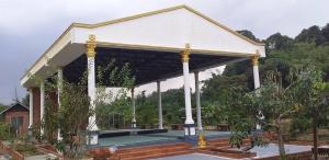 a pavilion with a tennis court in a garden at Seri Kenangan Holiday Home in Kota Samarahan