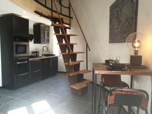 a kitchen with a wooden spiral staircase next to a table at Tour de Lacuzon in Dole