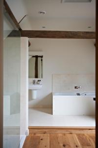 cocina con paredes blancas y suelo de madera en Manor Farm Courtyard Cottages en Hampstead Norris