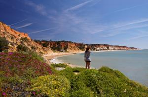 a person standing on a beach near the water at PortoBay Falesia in Albufeira