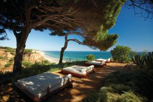 a row of chaise lounges sitting on a beach at PortoBay Falesia in Albufeira