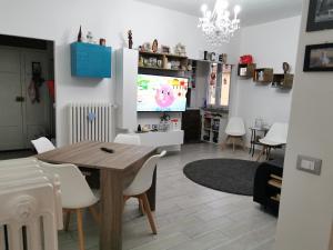 uma sala de estar com uma mesa de jantar e uma televisão em Zenzero e Limone em Pisa