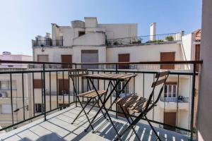 un par de sillas sentadas en la parte superior de un balcón en LovelyStay - Sunshine Residence in the Heart of Graça, en Lisboa