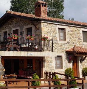 ein Gebäude mit einem Balkon mit Blumen darauf in der Unterkunft Casa Rural Juntana in Abionzo