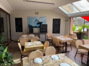 a restaurant with tables and chairs in a room at Le Trymen in Saint-Guénolé