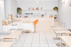 a restaurant with tables and chairs and a counter at Miu Hotel in Milan