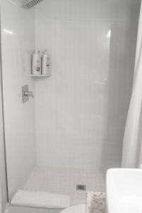 a white bathroom with a shower and a toilet at Sunset Oasis in Tampa