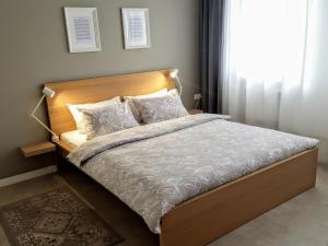 uma cama com cabeceira e almofadas de madeira em Autentic Home em Klaipėda