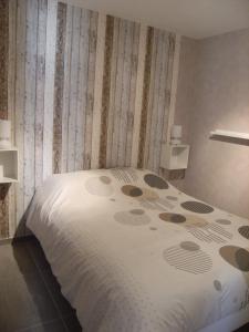 a bedroom with a bed with a white comforter at La maison de Louna in Saint-Parres-lès-Vaudes