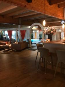 a living room with a bar with chairs and a couch at Hotel Thermen Mineraal in Rijmenam