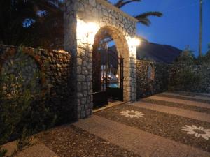 a stone building with a gate with lights on it at Petra Nera in Perissa