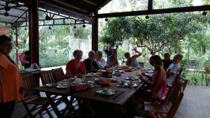 a group of people sitting around a table at Coconut Homestay Mỏ Cày Nam Bến Tre in Ben Tre