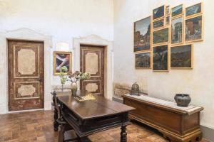 a room with a table and paintings on the wall at Boutique Apartment Urbino in Urbino