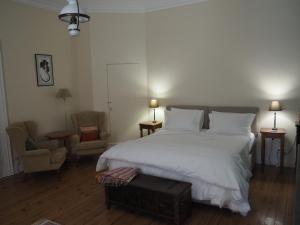 サント・フォワ・ラ・グランドにあるLe Cerisierのベッドルーム1室(大きな白いベッド1台、椅子2脚付)