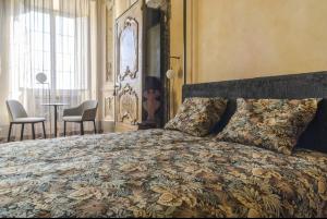 1 dormitorio con 1 cama y 1 mesa con sillas en Boutique Apartment Urbino, en Urbino