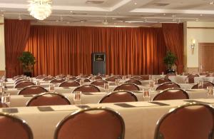 a conference room with tables and chairs and a curtain at Hotel Steglitz International in Berlin