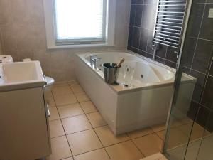 a bathroom with a bath tub and a sink at Washington House Hotel in Bournemouth