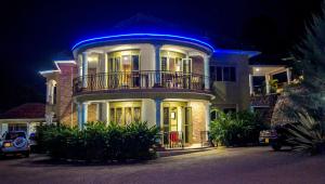 a large house with a blue light on it at Jowillis Hotel in Kabale