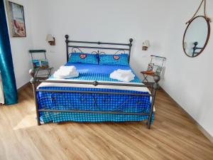 a blue bed in a room with a wooden floor at LE GIÜE in Genova