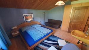 niewielka sypialnia z niebieskim łóżkiem i umywalką w obiekcie Göllblick w mieście Sankt Koloman