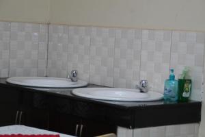 a bathroom with two sinks and two bottles of soap at Jowillis Hotel in Kabale