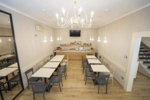 a restaurant with tables and chairs and a chandelier at Albergo Africa in Volterra