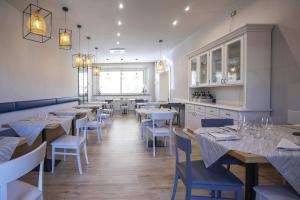a dining room with tables and chairs and a kitchen at Albergo Africa in Volterra