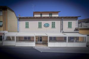 - un grand bâtiment blanc avec un panneau dans l'établissement Albergo Africa, à Volterra