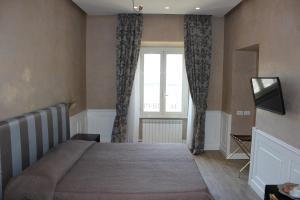 a bedroom with a large bed and a window at Relais La Maison De Luxe in Rome