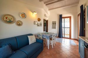 un salon avec un canapé bleu et une table dans l'établissement Country House il Gelso e l'Ulivo appartamento in villa l'Ulivo, à Noto