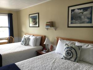 Bridgton的住宿－Highland Lake Resort，一间卧室设有两张床和窗户。