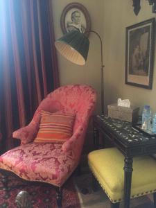 une chambre avec une chaise, une lampe et une table dans l'établissement La Maison Rousseau Chambre d'hôtes, à Nîmes