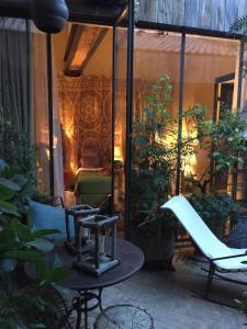 patio z krzesłem i stołem w obiekcie La Maison Rousseau Chambre d'hôtes w mieście Nîmes
