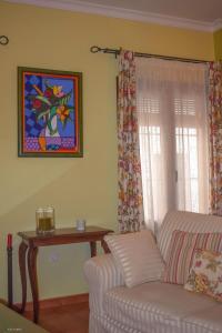 salon z kanapą i oknem w obiekcie CASA BLANCAFLOR w mieście Peñaflor