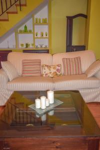 uma sala de estar com um sofá e uma mesa de vidro em CASA BLANCAFLOR em Peñaflor