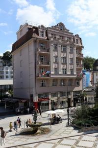 a large building with a clock on the side of it at Art Deco WOLKER by ASTORIA Hotel & Medical Spa in Karlovy Vary