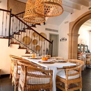 a dining room with a table and wicker chairs at Stadthotel Santanyi in Santanyi