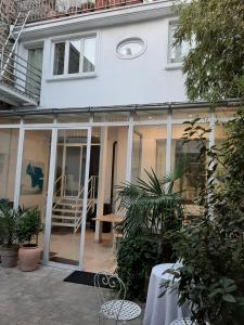 una casa con puertas correderas de cristal en un patio en Villa des iris, en París