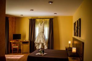 a wedding dress hanging from a window in a room at Hostal Rural el Nacimiento in Deifontes