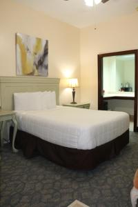 um quarto com uma grande cama branca e um espelho em The Prytania Park Hotel em Nova Orleans