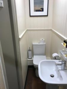 a bathroom with a sink, toilet and mirror at The Wheatsheaf Hotel in Newport