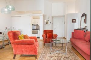 a living room with two red chairs and a glass table at Flowers' Lane in Milan