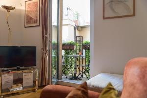 a living room with a couch and a tv and a balcony at Flowers' Lane in Milan