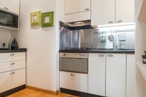 a kitchen with white cabinets and a stove at Flowers' Lane in Milan