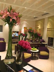 un vestíbulo con jarrones de flores sobre una mesa en Vivienda Hotel Villas, en Riad