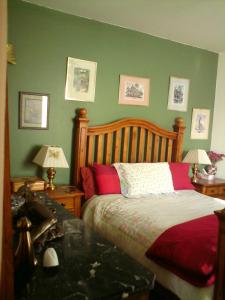 um quarto com uma cama com paredes verdes e 2 candeeiros em Les Trois Puits em Brion-près-Thouet
