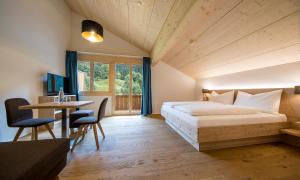 Gadmer Lodge - dein Zuhause in den Bergen في Gadmen: غرفة نوم بسرير وطاولة ومكتب