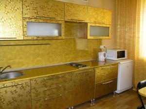 cocina con fregadero y microondas en Apartments on Buinskiy 1, en Ulyanovsk