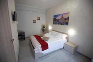 1 dormitorio con cama blanca y mesa en Rooms Monteverde 2, en Roma